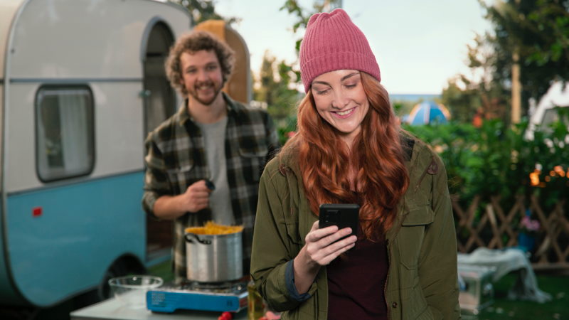 Woman checking phone while camping