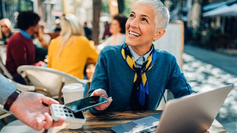 Woman paying at an outside cafe